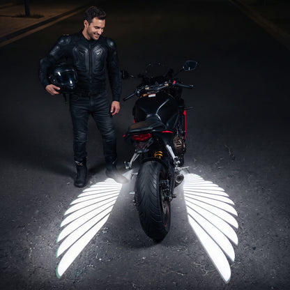 Motorcycle at night with two white angel wings of light on the ground
